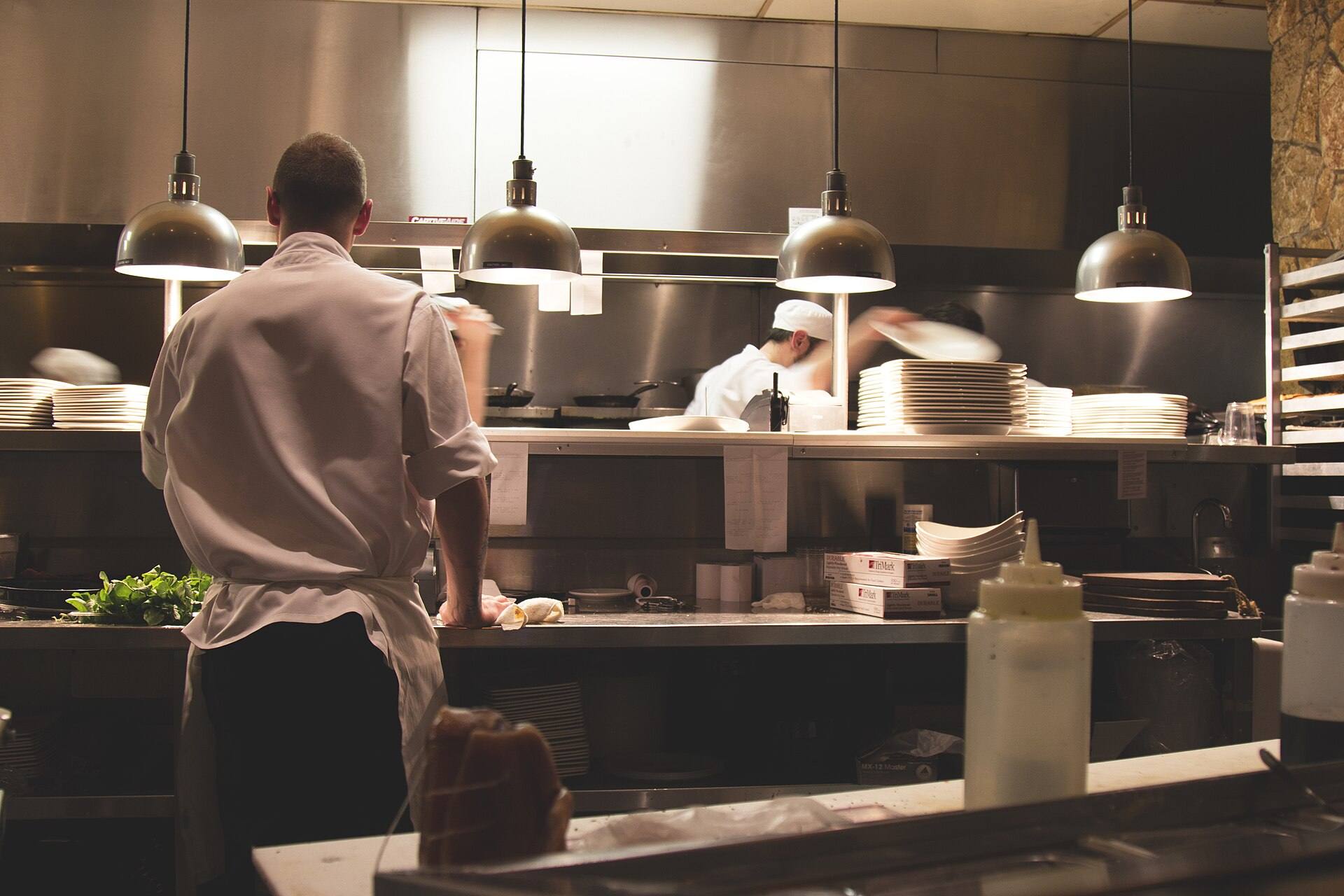 Chefs working in a stainless steel commercial kitchen